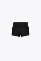 Falda pantalón corta negra de tiro medio con corte asimétrico.