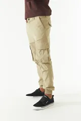 Pantalón cargo gris con puños elásticos, corte regular, bolsillos laterales con solapa y pasacintos.