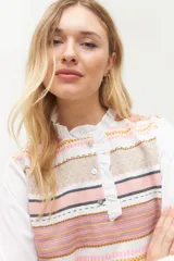 Blusa rosada con mangas largas, cuello con volados y estampado de líneas verticales.