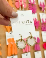 Par de aros colgantes con aro de acero dorado y dije circular de acrílico blanco con borde de strass.