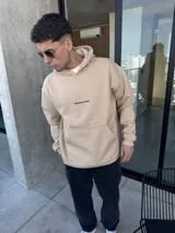 Canguro beige de algodón con corte oversize y logo bordado en el pecho.