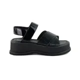 Sandalias negras de plataforma con dos tiras anchas, una de charol y otra con textura tipo cocodrilo.