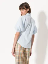 Camisa negra de popelina, de silueta amplia y diseño liviano. Incluye cuello clásico y cierre frontal con botones.