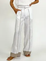 Pantalón gris de lino con corte palazzo y detalle de costuras amarillas en los laterales y en el ruedo.