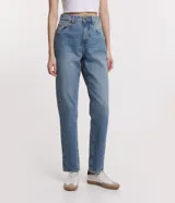 Pantalón de jean celeste, de corte recto y tiro alto, con bolsillos delanteros y traseros, y cierre con botón y cremallera.
