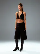 Pantalón culotte negro de vestir, con tiro alto, corte ancho y largo a la pantorrilla.