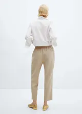 Pantalón color verde oliva, de tejido fluido, corte recto, tiro alto, cintura elástica con cordón de ajuste y bolsillos laterales.