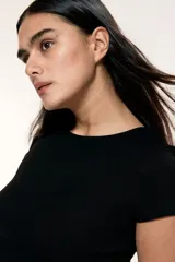 Remera corta negra de punto fino suave, entallada con cuello redondo ribeteado acanalado.