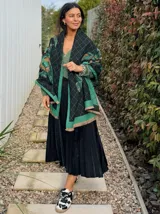 Falda midi plisada de satén color negro, con cintura elástica.