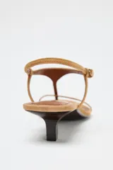 Sandalia de tacón kitten color tostado, con tiras finas de ante y cierre de hebilla ajustable en el tobillo.