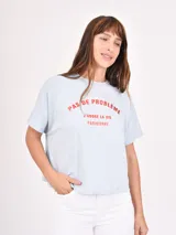 Remera blanca de corte recto con estampado de flores rojas y texto azul "PROFUMO DI FIORI".