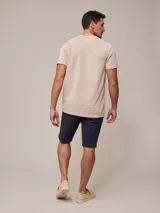 Bermuda color beige, de corte recto y largo hasta la rodilla.