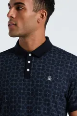 Polo de manga corta color azul marino con cuello y tapeta de botones en color liso. Presenta un estampado jacquard de círculos concéntricos en tono más claro.