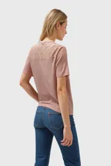Remera gris con detalle de encaje calado en el cuello y hombros, de corte recto y manga corta.