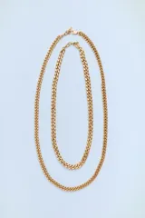 Set de dos collares dorados con cadena de eslabones metálicos de diferente longitud. Cierre con mosquetón.