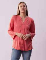 Blusa color salmón texturizada, marca Ninety. Cuello a la base, escote en V y abertura central con botones. Delantera con bolsillo. Largo de manga regulable con presilla y botón.