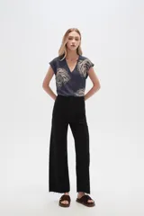 Pantalón de jean color beige, de corte flare y tiro alto, con terminación desflecada.