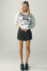 Sudadera gris melange de cuello redondo y manga larga con puños elásticos. Estampado frontal con texto "Chicago Harlem" y dibujo de Betty Boop.