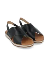 Sandalias negras con tiras cruzadas de cuero y suela blanca.