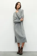 Maxivestido de punto gris, de manga larga y cuello alto, con aberturas laterales.