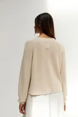 Sweater de punto color crudo, de corte recto y mangas largas.