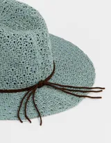 Sombrero de paja celeste con ala ancha y cinta trenzada marrón.