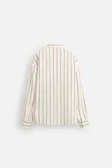 Camisa de hombre regular fit, color blanco con rayas verticales negras, cuello solapa, manga larga con puños abotonados y cierre frontal con botones.