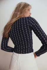 Top azul marino acanalado con estampado de flores blancas, mangas largas y escote cuadrado con ribete de picot.