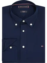 Camisa azul marino de corte slim, confeccionada en tejido dobby de algodón con Flex Technology, cuello abotonado, puños redondeados con dos botones y logo de Tommy Hilfiger bordado en el pecho.