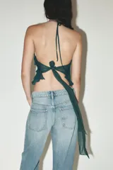 Top verde esmeralda con cuello halter, volantes escalonados y espalda descubierta con lazo.