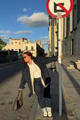 Pantalón de jean azul oscuro con bajo doblado.