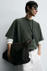 Remera verde oscuro de corte oversize, manga corta y cuello redondo.