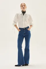 Jean acampanado de tiro alto, color azul medio, confeccionado en denim con un pequeño porcentaje de elastano.