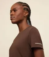 Remera deportiva blanca texturizada, con cuello redondo, manga corta, detalle reflectante y pliegue en la espalda.