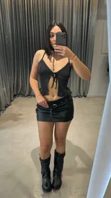 Top negro con brillos, breteles finos y escote en V con lazo ajustable.