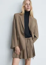 Minifalda marrón con estampado pata de gallo, corte evasé, tiro medio, tablas y lazo lateral.