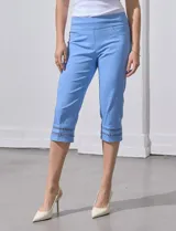 Pantalón capri blanco de gabardina elastizada con bolsillos simulados, pretina ancha, corte recto y detalle de puntilla en el ruedo.
