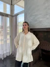 Camisa celeste con estampado de flores blancas, de corte holgado y manga larga.