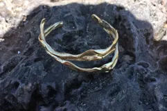 Brazalete rígido de bronce y alpaca maciza, con diseño orgánico irregular.