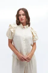 Camisa amarilla de lino con cuello mao y mangas cortas abullonadas con volados.