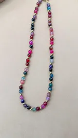 Collar corto de cuentas de piedra ágata multicolor con separadores de pequeñas esferas doradas.