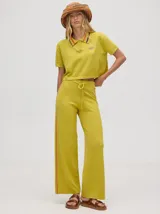 Pantalón de algodón negro, corte holgado y pierna ancha con pretina elástica. Presenta rayas bicolor al costado en blanco y celeste. Calce de tiro alto.