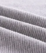 Suéter de punto color gris, con cuello redondo, manga larga y textura maquinetada.