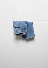 Pantalón de jean celeste, de corte mom-fit, tiro alto, con cinco bolsillos y cierre de cremallera y botón.