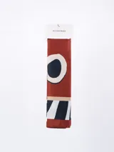 Pañuelo rectangular con estampado abstracto en tonos terracota, negro, blanco y beige.