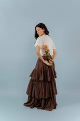 Blusa negra con bordado calado, escote en V con lazos para atar y mangas cortas abullonadas.