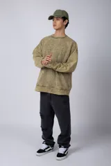 Buzo de friza color gris con cuello redondo y teñido artesanal, de corte oversize.