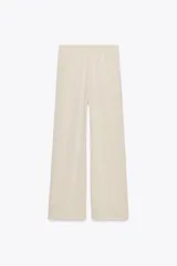 Pantalón de punto color beige, de tiro alto con cintura elástica ajustable con cordones y corte ancho.