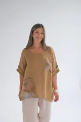 Blusa color camel de corte holgado, con cuello redondo, mangas cortas con dobladillo y apliques de tela estampada en el frente.