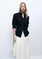 Falda midi color crudo, de tejido de punto fino y corte peplum.